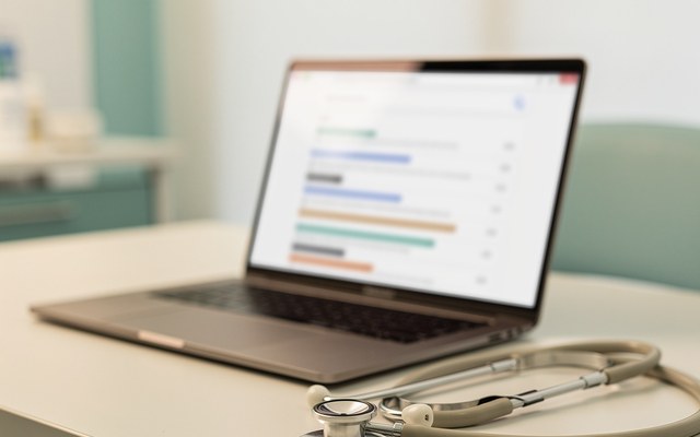A person searching for health symptoms on a laptop with search results on screen